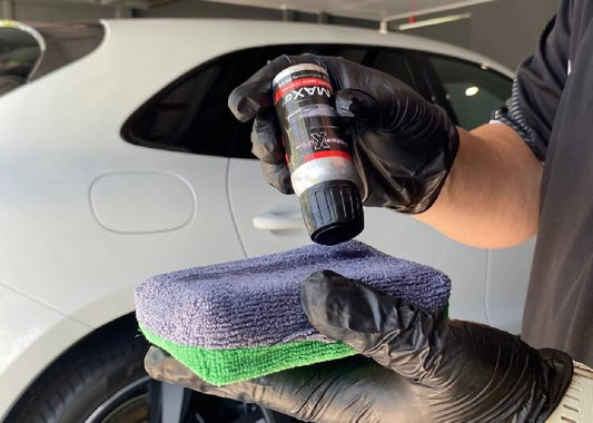 gloved hands getting ready to ceramic coat a white car